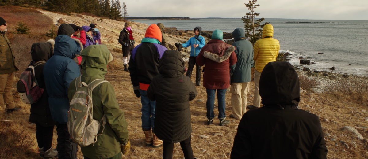 photo of people listening to one person on maine coast in winter