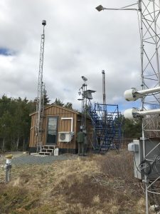 The monitoring station consists of metal towers and a small shed with various instruments on and around it.