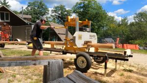 Mark Cross puts logs through a mechanical saw mill.