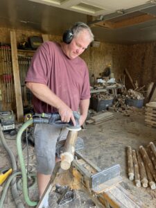 Mark Cross in his workshop sanding legs of what will become the benches.