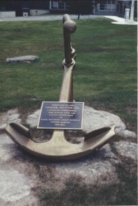 Anchor to commemorate Navy in foreground, grass in background 