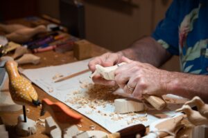 Close up of hands carving a bird out of wood