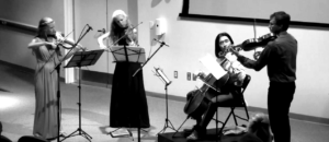 String quartet playing instruments in auditorium
