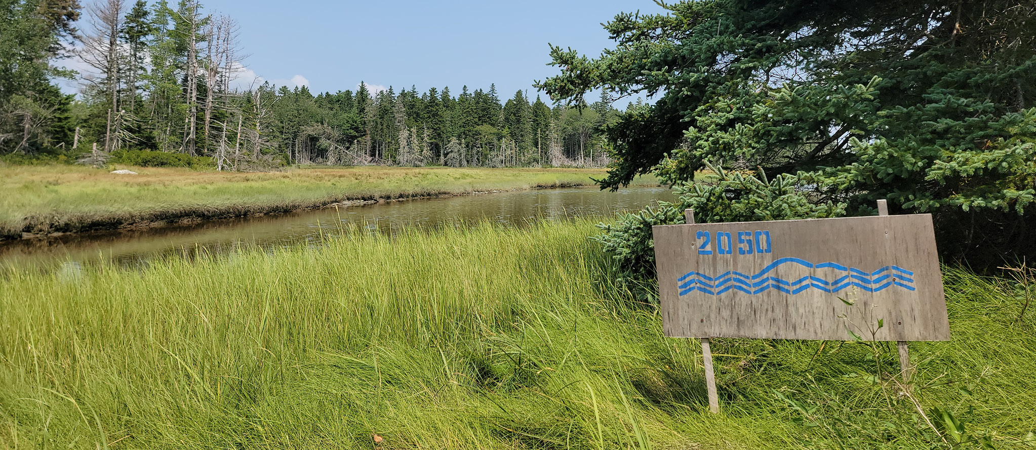 A stenciled sign reading "Coastlines" shows the sea level rise at the Oceanarium in Bar Harbor, Maine