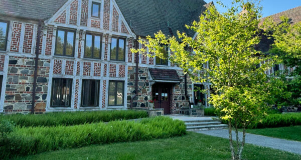 Front entrance of the Welcome Center at Rockefeller Hall on a bright, sunny day